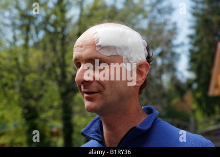 Ritratto di un uomo, 45, con un bendaggio adesivo sulla sua testa, Geretsried, Baviera, Germania, Europa Foto Stock