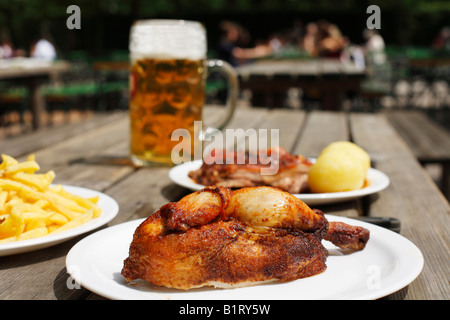 La metà di un pollo arrosto servita in un giardino della birra in Taxisgarten, Monaco di Baviera, Germania, Europa Foto Stock