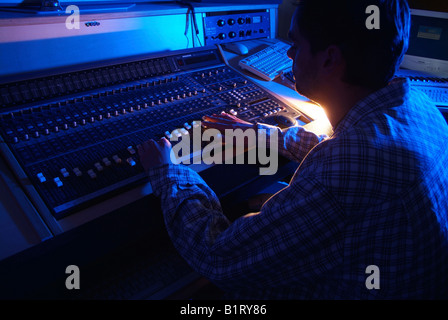 Ingegnere del suono lavorando su un gruppo mescolatore di uno studio di registrazione Foto Stock