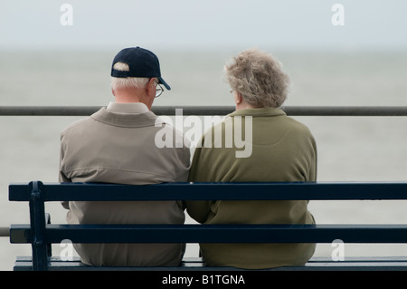 Coppia di anziani seduti insieme sul banco a mare Wales UK Foto Stock