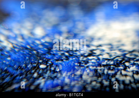 Una macro vista dell'interno di un blu e bianco fermacarte in vetro. Il primo piano ha prodotto un astratto modello di vorticazione. Foto Stock