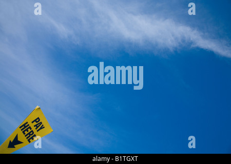 "Pagare qui' segno parcheggio nuovo cielo blu, il bianco delle nuvole per parcheggio auto a pagamento in Inghilterra UK GB Isole britanniche Foto Stock