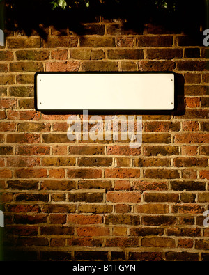 BLANK cartello stradale sul vecchio muro in mattoni Foto Stock