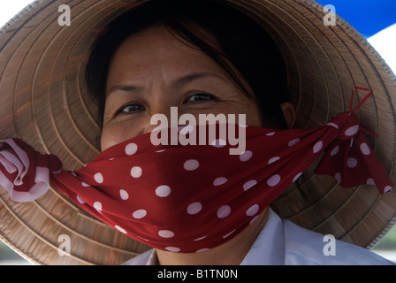 Ritratto donna che indossa cappello conico e la maschera di Cai Rang Mercato Galleggiante lungo il delta del Mekong Il Vietnam Foto Stock