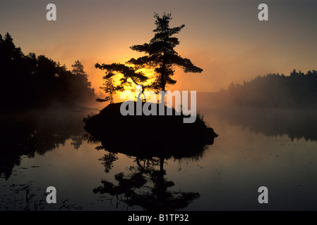 Il sorgere del sole dietro la piccola isola nella baia di McGregor, Il Lago Huron, Ontario. Foto Stock