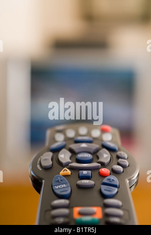 Un telecomando puntato verso un televisore mostra il concetto del lettino potatoe Foto Stock