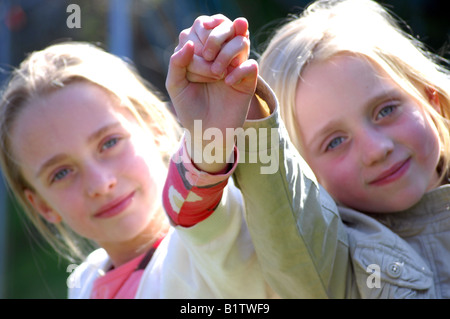 Fotografia delle due sorelle fiducioso giocare felicemente nel loro giardino e sorridente alla fotocamera. Foto Stock