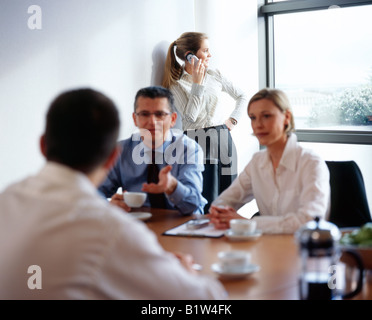 Donna con telefono cellulare al business meeting Foto Stock