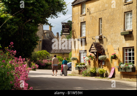 English pub di campagna in Cotswolds village di potenza Guiting Gloucestershire Inghilterra giovane spingendo un passeggino Foto Stock