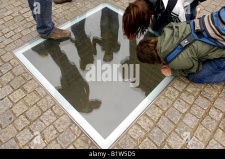 Studenti circondano lastra di vetro che commemora la combustione dei libri da parte dei nazisti bebelplatz patrimonio di storia Berlino Germania Foto Stock