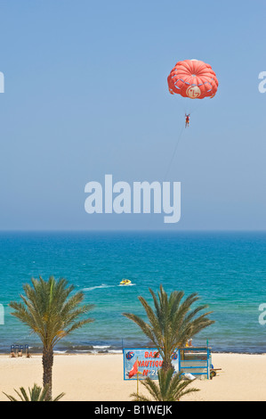 Un ampio angolo di visione di parasailing vicino a Hammamet in Tunisia in una giornata di sole contro un luminoso cielo blu. Foto Stock