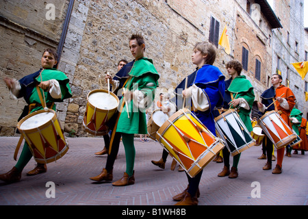 Italia Toscana San Gimignano ragazzi e giovani uomini in costume medievale di tamburi in sfilata per le strade durante il corteo storico Foto Stock