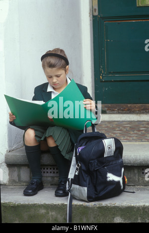 Bambino seduto sulla porta di attesa per i genitori per tornare a casa Foto Stock