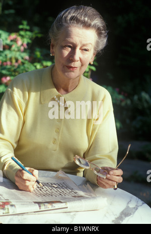 Donna anziana facendo il cruciverba per mantenere mentaly alert Foto Stock