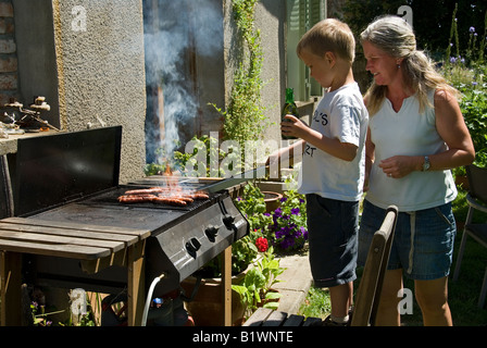 Stock Foto di un giovane ragazzo imparare a barbecue Foto Stock