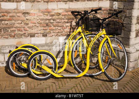 Kickbikes per noleggio, a sinistra contro il lato del Stadhuis, Markt Square, in Delft. Paesi Bassi. Foto Stock