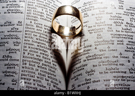 Un anello in una bibbia una colata a forma di cuore ad ombra Foto Stock
