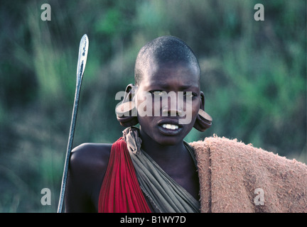 Ritratto di uomo Masai in abito tradizionale indossando grande tappi in legno come orecchio decorazioni Kenya meridionale Africa orientale Foto Stock