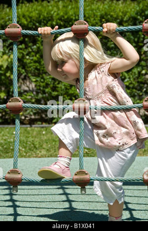 Stock Foto di un bambino di due anni un alpinismo arrampicata corda telaio Foto Stock