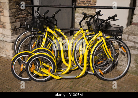 Kickbikes per noleggio, a sinistra contro il lato del Stadhuis, Markt Square, in Delft. Paesi Bassi. Foto Stock