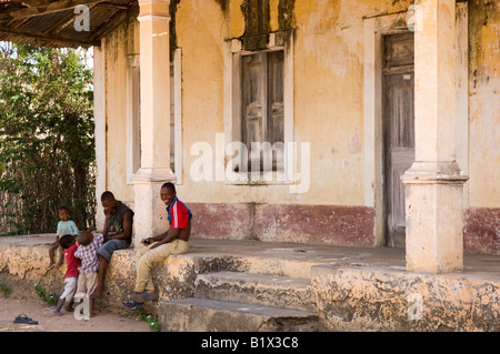 Famiglia seduto davanti a un fatiscente villa coloniale su ibo island. Mozambico Foto Stock