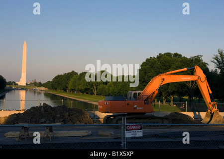 Un arancione escavatore Hitachi siede su un lato della costruzione a piedi la zona tra il Monumento a Washington e il Lincoln Memorial DC USA Foto Stock