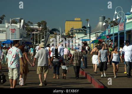 Guardando la lunghezza di Santa Monica Pier, verso l'ingresso, con una folla di persone presenti. Foto Stock
