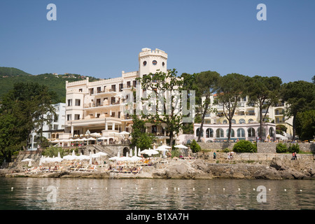 Opatija Istria Croazia Europa vista Offshore di elegante Lungomare Hotel Miramar con la gente a prendere il sole sulla spiaggia di cemento Foto Stock