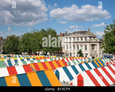 Vivacemente colorato tetti di bancarelle SUL MERCATO DI NORWICH CON LLOYDS BANK BUILDING IN BACKGROUND NORFOLK England Regno Unito Foto Stock