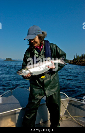 Donna che mantiene un grande coho Salmone BC pesce a isole nodose in British Columbia settentrionale Foto Stock