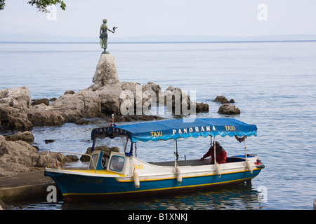Opatija Istria Croazia Europa Può acqua taxi imbarcazione sulla spiaggia rocciosa dalla fanciulla con la statua di gabbiano su Kvarner Gulf Coast Foto Stock