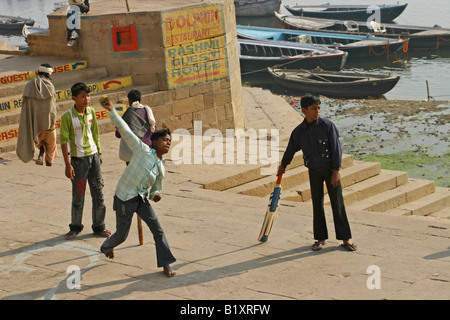 Ragazzi giocare a cricket sulle rive del fiume Gange, Varanasi Foto Stock