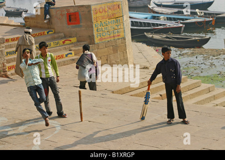 Ragazzi giocare a cricket sulle rive del fiume Gange, Varanasi Foto Stock