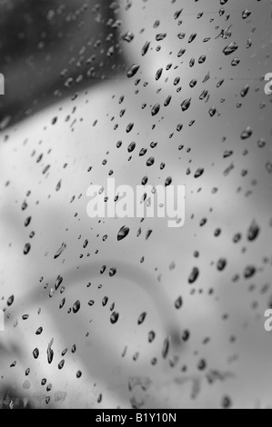 Una fotografia in bianco e nero di gocce di pioggia sul cofano di un'auto. Foto Stock