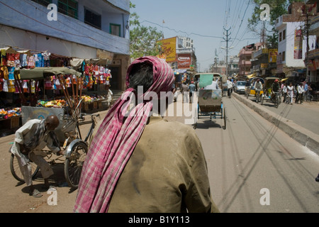 Cycle rickshaw driver su strada trafficata di Varanasi, Uttar Pradesh, India. Foto Stock