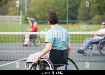 Tre uomini disabili costretti su sedie a rotelle e giocare a tennis Foto Stock