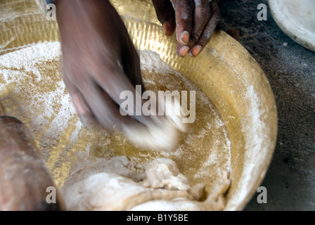 Una madre di Rajasthan deserto di Thar India prepara chapati un fiocco focaccia di azzimo pasta cotta, tipo di roti. Foto Stock