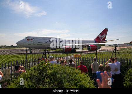 Persone che guardano un Virgin Atlantic Boeing 747- 400 piano preparare per il decollo. Foto Stock