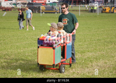 Due giovani ragazzi essendo spinto in un carrello al Glastonbury Festival 2008 Foto Stock