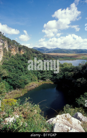 Il Cenote Agua Azul (in primo piano) presso le rovine Maya di Chinkultic vicino Comitan. In Chiapas, Messico. Foto Stock