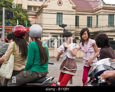 Il traffico di moto e ragazza pedoni in strada trafficata in Hanoi, Vietnam Foto Stock