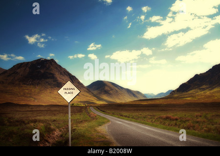 Passando segno posto accanto alla strada vuota Foto Stock