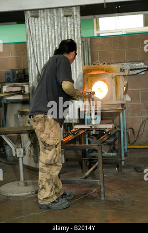 Regno Unito Wearside Sunderland National Glass Centre artigiano dimostrando di vetro tradizionali competenze di soffiatura del vetro di riscaldamento in forno Foto Stock