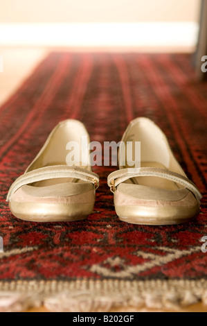 Una coppia di donna s scarpe a sinistra dietro sul tappeto orientale Foto Stock