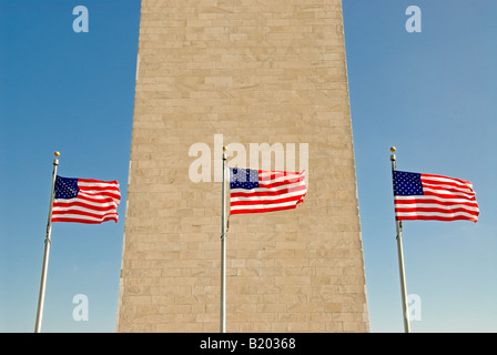 WASHINGTON, DC, Stati Uniti: Il monumento a Washington si erge alto sul National Mall, circondato da un cerchio di bandiere americane. Questo iconico obelisco, dedicato al primo presidente degli Stati Uniti George Washington, è incorniciato da stelle e strisce, creando una potente immagine del patriottismo e della storia americani. Le bandiere, solitamente esposte per festeggiamenti nazionali o festività, aggiungono un elemento vibrante al marmo bianco scuro del monumento. Foto Stock