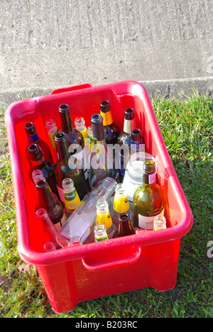 Ordinati domestiche Rifiuti di vetro riciclabile in riquadro rosso posto a marciapiede attendono collection Foto Stock