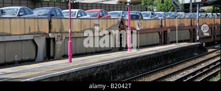 Primo piano di carri a due piani su un treno merci che trasporta un carico di auto nuove che viaggiano attraverso la stazione ferroviaria di East London, Inghilterra, Regno Unito Foto Stock