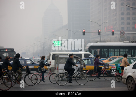 Per i ciclisti e per il traffico congestionato attraverso l'inquinamento atmosferico su Pechino strada principale Chang An Avenue Cina Foto Stock