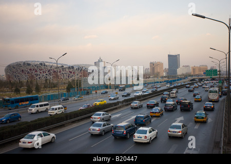 Il traffico su autostrada passa sito Olimpiadi dello Stadio Nazionale di Pechino Bird s Nest Cina Foto Stock