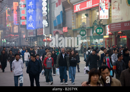 Pedoni affollata Wangfujing street e negozi in smoggy centrale di Pechino CINA Foto Stock